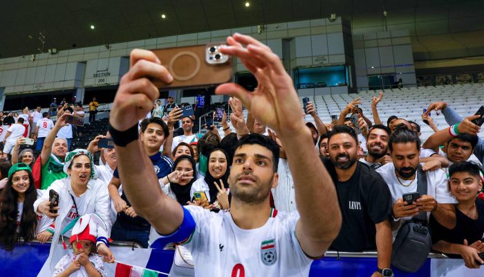 Atacante Mehdi Taremi tira selfie com torcedores após partida entre Irã e Qatar pelas Eliminatórias asiáticas, em Doha 
             -       
        Karim Jaafar - 5.jun.2025/AFP