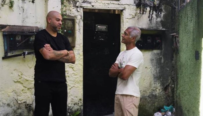 Adriano d&aacute; entrevista para Rom&aacute;rio na porta da casa da av&oacute;, na Vila Cruzeiro