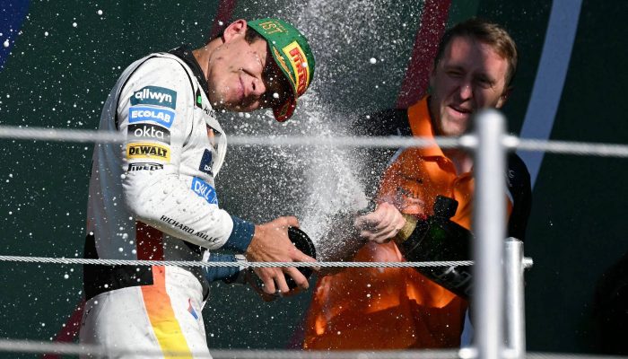 Lando Norris (à esq.), da McLaren, comemora no pódio a vitória no GP do México, neste domingo (26)
             -       
        Yuri Cortez/AFP