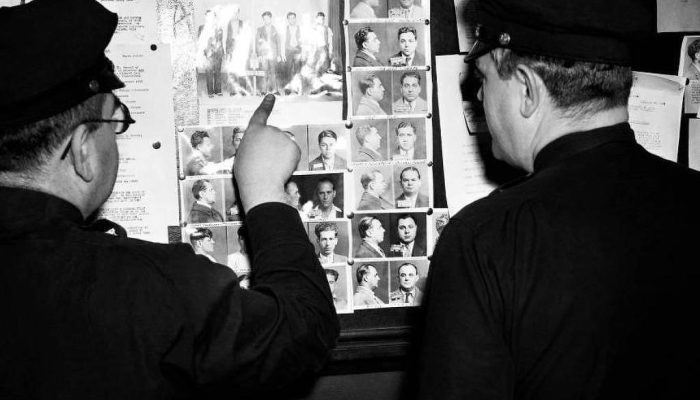 Policiais do Brooklyn apontam para a lista de supostos membros da gangue Murder Inc., por volta de 1940
             -       
        Getty Images