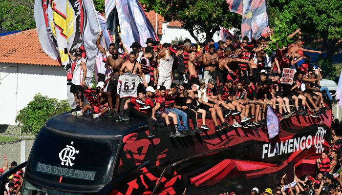 Torcedores sobem no teto do ônibus do elenco do Flamengo na chegada ao aeroporto internacional do Galeão, no Rio Janeiro
             -       
        Pablo Porciuncula/AFP