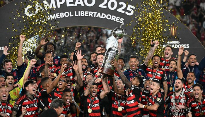 Jogadores do Flamengo levantam a taça após a vitória na final da Copa Libertadores disputada contra o Palmeiras no Estádio Monumental em Lima, Peru
             -       
        Luis Acosta/AFP