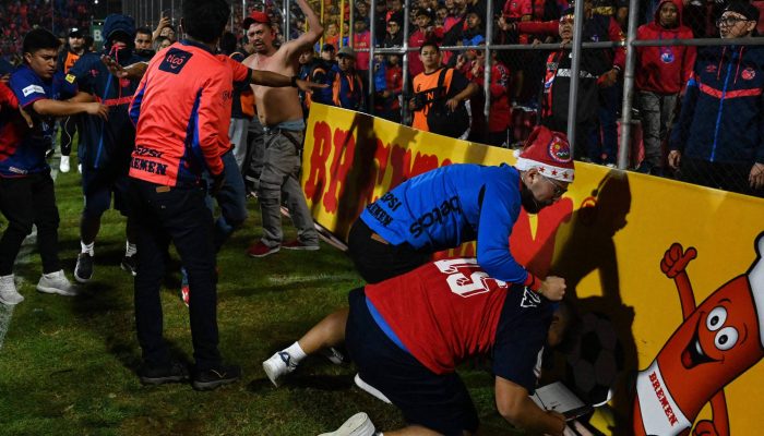 Confusão entre torcedores e jogadores ao final da partida de volta da final do torneio Apertura na Cidade da Guatemala
             -       
        Johan Ordonez/AFP