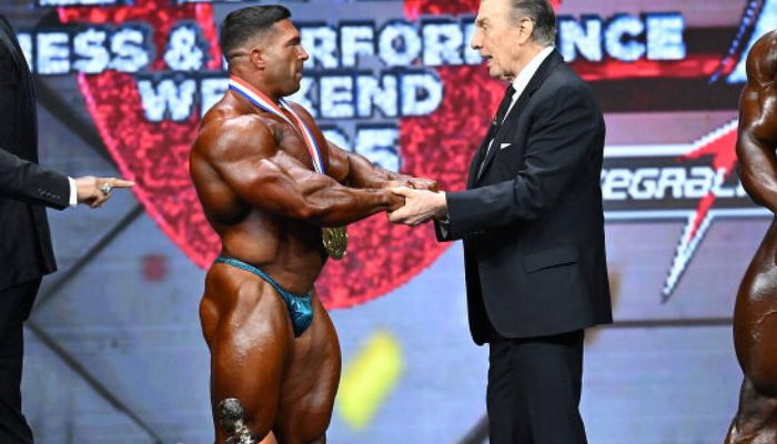Jim Manion, atual presidente da 'IFBB Pro League', parabeniza Derek Lunsford pelo seu título no Olympia 2025
             -       
        Jeff Binns/NPC News Online
