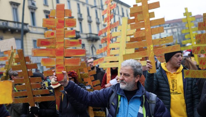 Manifestantes carregam árvores de papelão em protesto contra os Jogos de Inverno, em Milão
             -       
        Claudia Greco/Reuters