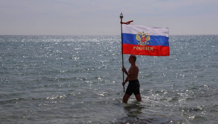 Homem carrega bandeira russa durante comemorações do aniversário da anexação da Crimeia pela Rússia em uma praia de Yevpatoriya, no Mar Negro

             -       
        Alexey Pavlishak - 18.mar.26/Reuters