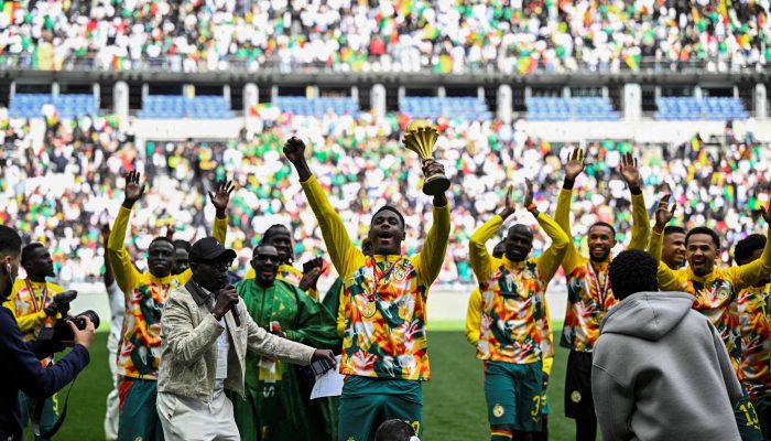 Jogadores de Senegal exibem troféu da Copa Africana de Nações antes de amistoso contra o Peru, em Paris
             -       
        Julien de Rosa/AFP