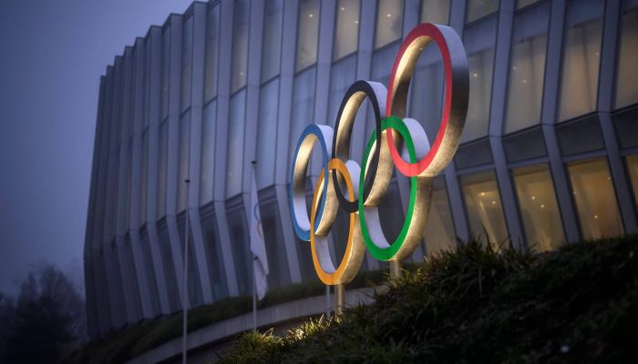 Anéis olímpicos na entrada do Olympic House, em Lausanne, na Suíça
             -       
        Fabrice Coffrini - 9.dez.25/AFP