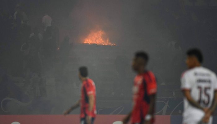 Torcedores do Medellín atearam fogo nas arquibancadas durante partida da fase de grupos da Libertadores com o Flamengo
             -       
        Jaime Saldarriaga/AFP