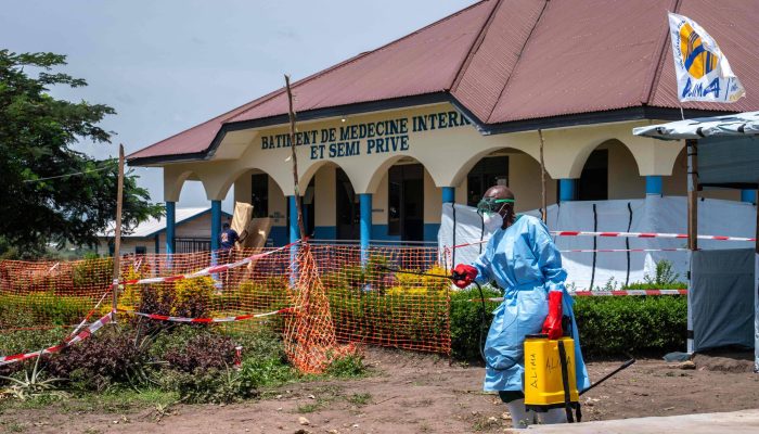 Profissional de saúde carrega um dispositivo de desinfecção enquanto caminha pelo Hospital Rwampara em Ituri, no leste da República Democrática do Congo
             -       
        Glody Murhabazi - 25.mai.26/AFP