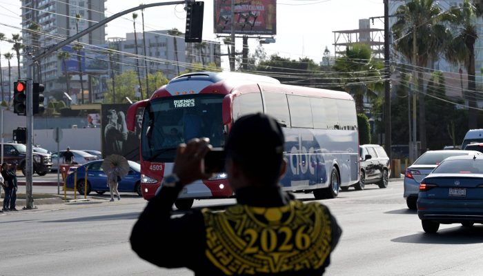Membros da Guarda Nacional do México filmam ônibus que transporta seleção do Irã até local de treino em Tijuana
             -       
        Guillermo Arias - 8.jun.26/AFP