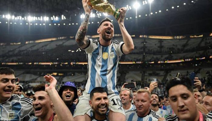 O jogador argentino Lionel Messi ergue o troféu da Copa do Mundo enquanto é carregado nos ombros pelo ex-jogador Sergio Agüero durante as celebrações da conquista da Argentina na Copa do Mundo de 2022
             -       
        AFP via Getty Images
