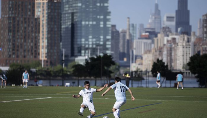 Migrantes da Guatemala jogam futebol no parque de Randall's Island, em Nova York  -              
                              
                  Eduardo Anizelli - 7.jun.26 /                
              
                              Folhapress